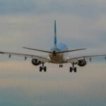 white and blue airplane in mid air during daytime